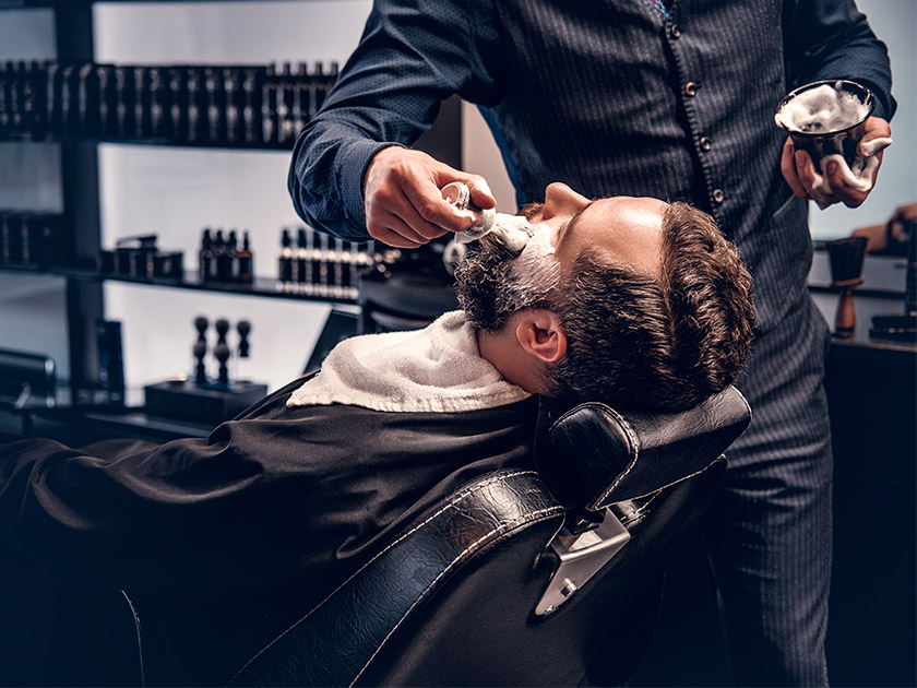 Hombre afeitándose en una barbería