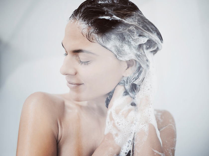 Mujer lavándose el pelo con champú